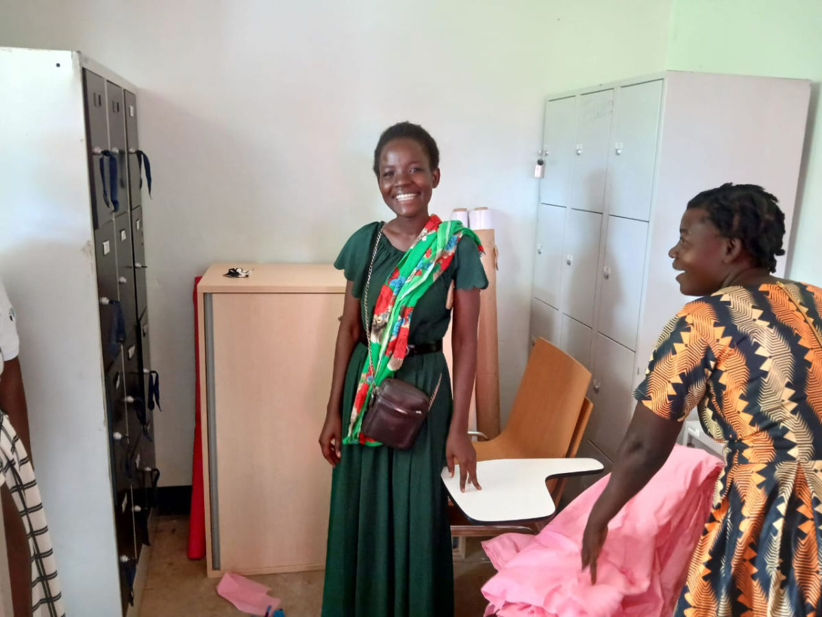 Zwei lachende Frauen zeigen die neuen Möbel.